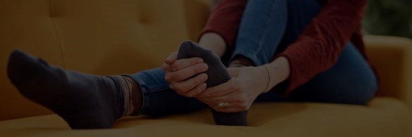Person on sofa massaging foot