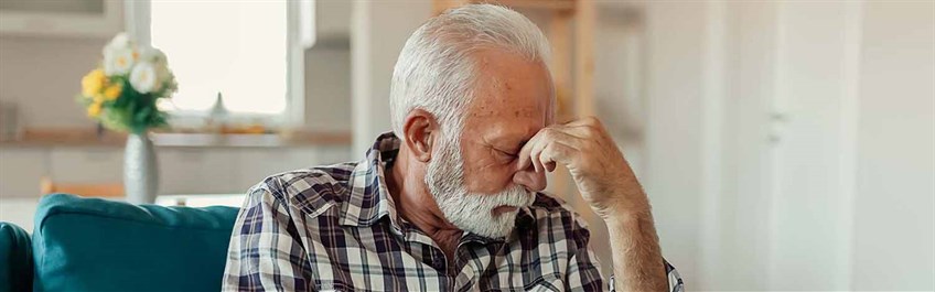 Man looking tired with hands to head