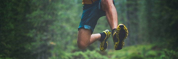 Man in running shoes jumping in the woods