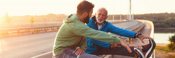 Two men stretching after a run