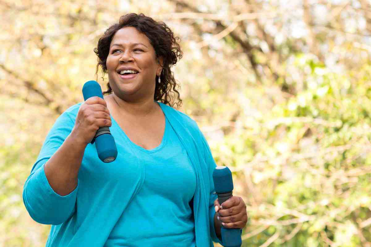 Woman exercising outside with weights