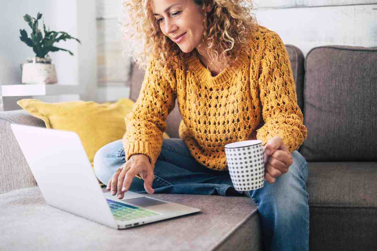 Woman in mustard jumper using laptop