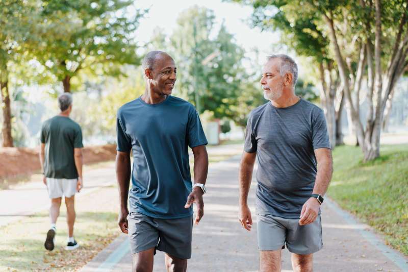 Two middle-aged male friends exercising in a park