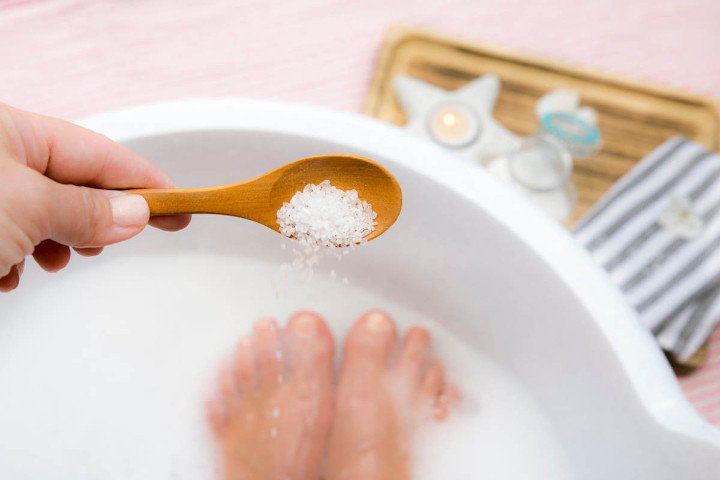 Woman adding magnesium to bath water